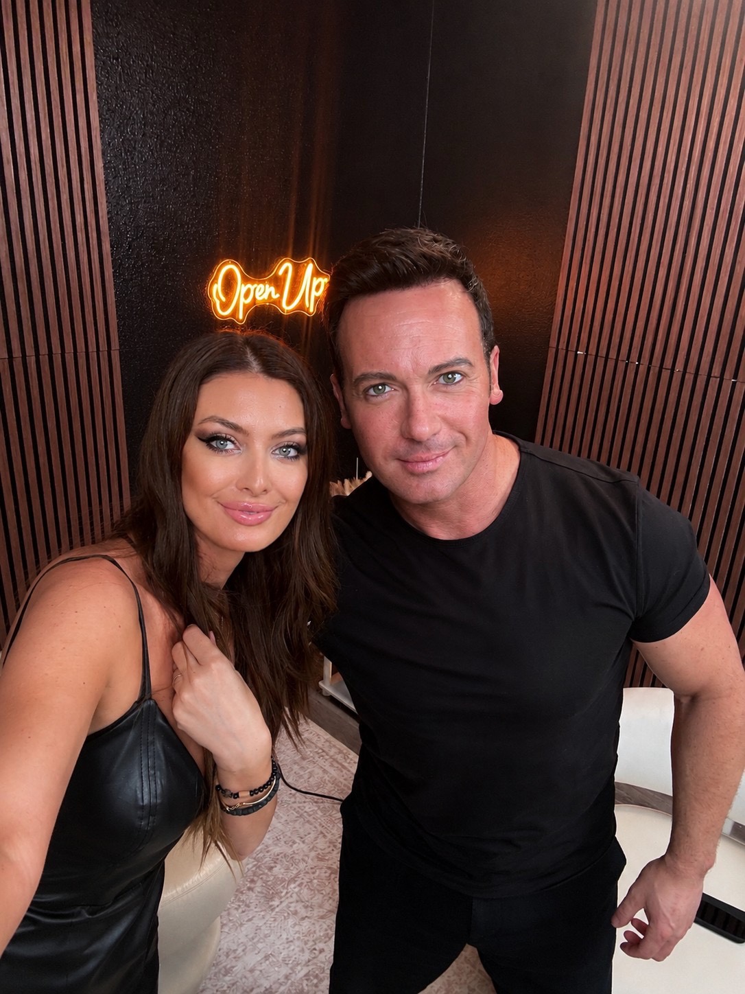 Catalina Magee with guest under Open Up neon